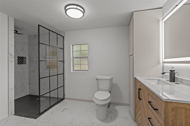 bathroom featuring vanity, toilet, a textured ceiling, and a tile shower