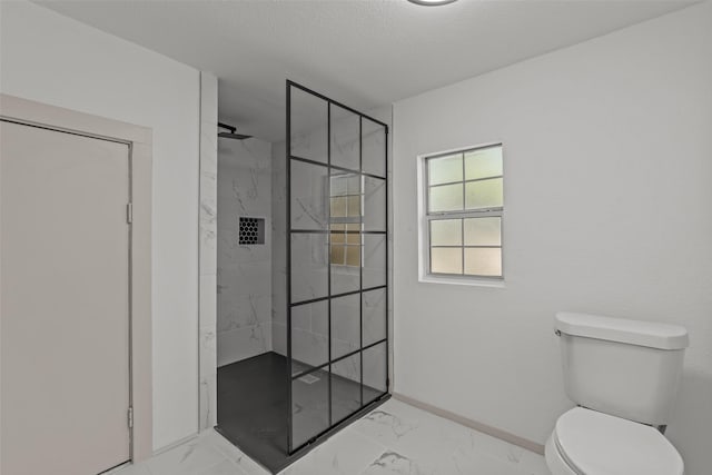 bathroom featuring a tile shower, a textured ceiling, and toilet