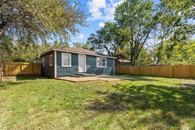 rear view of property featuring a yard