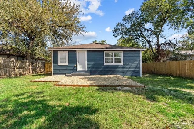 back of house with a patio area and a lawn