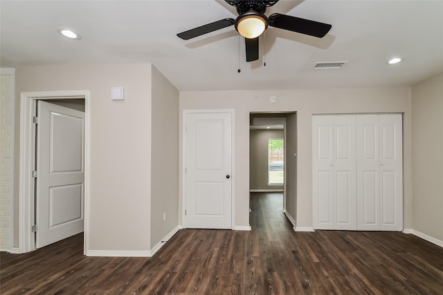 unfurnished bedroom featuring dark wood-type flooring, ceiling fan, and a closet