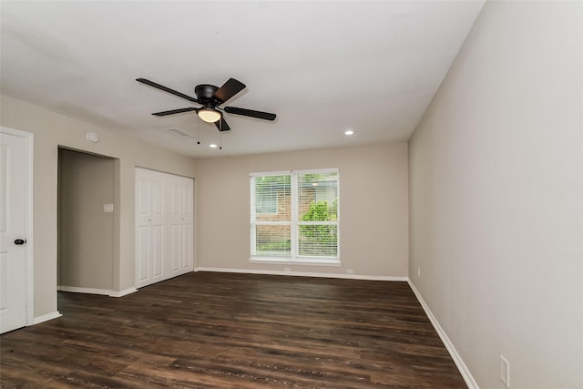 unfurnished bedroom with ceiling fan, dark hardwood / wood-style flooring, and a closet