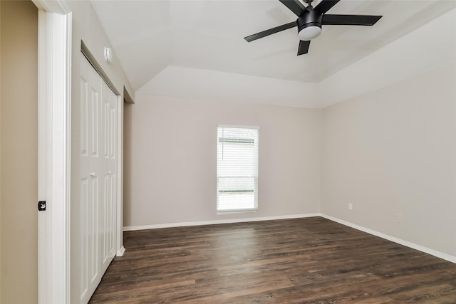 unfurnished bedroom with dark wood-type flooring, a closet, ceiling fan, and vaulted ceiling