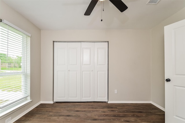 unfurnished bedroom with ceiling fan, dark hardwood / wood-style flooring, and a closet