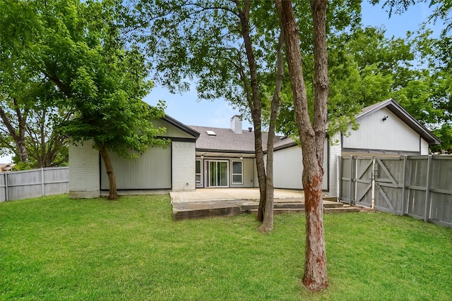 rear view of property featuring a lawn and a patio area