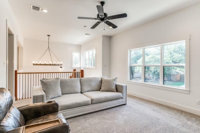 living room featuring carpet floors and ceiling fan with notable chandelier