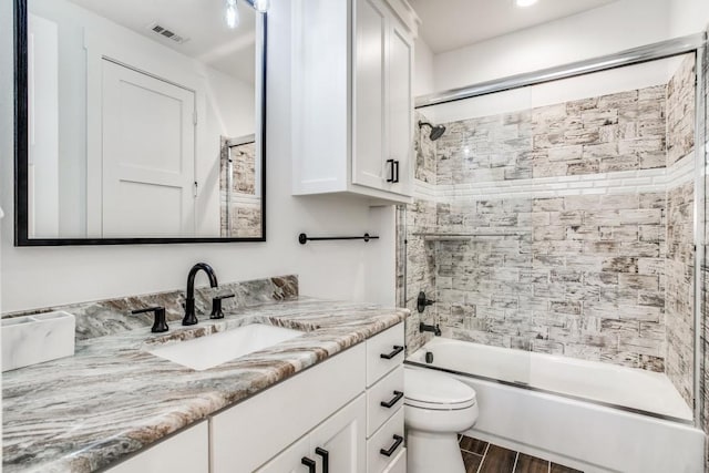 full bathroom featuring enclosed tub / shower combo, hardwood / wood-style floors, vanity, and toilet