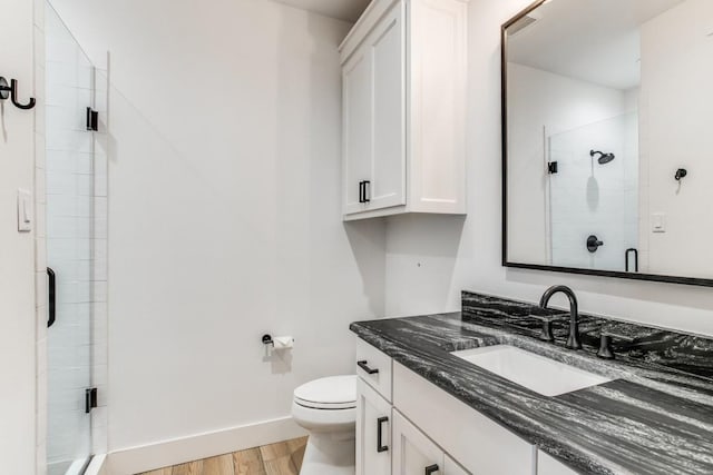 bathroom with vanity, hardwood / wood-style floors, an enclosed shower, and toilet