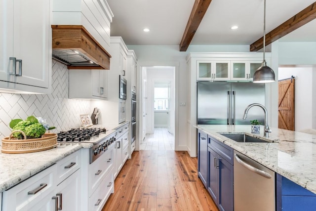 kitchen featuring built in appliances, decorative light fixtures, blue cabinetry, and white cabinets