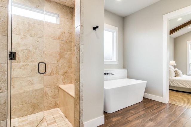 bathroom featuring hardwood / wood-style flooring, a healthy amount of sunlight, plus walk in shower, and sink