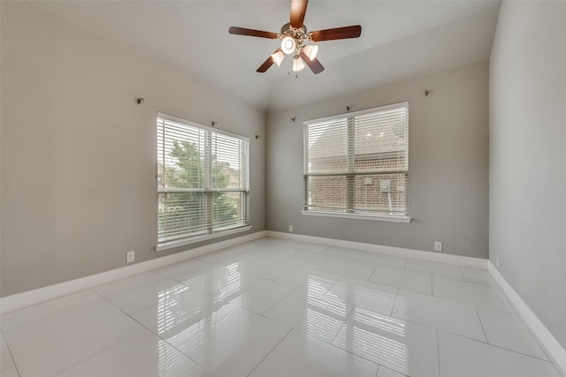 empty room with ceiling fan and light tile patterned floors