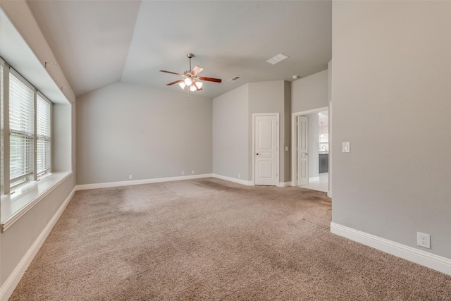 spare room with ceiling fan, lofted ceiling, and carpet floors