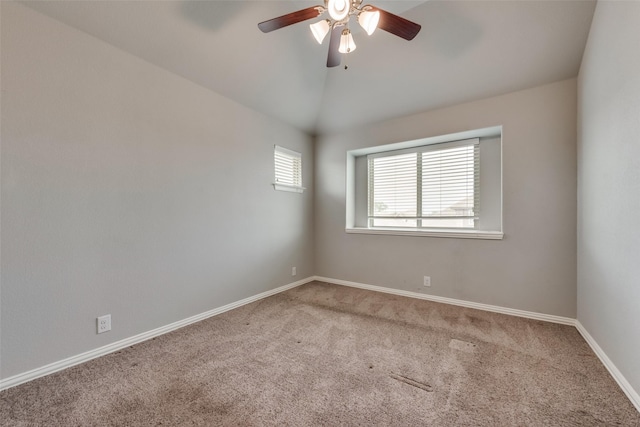 spare room with ceiling fan, vaulted ceiling, and carpet