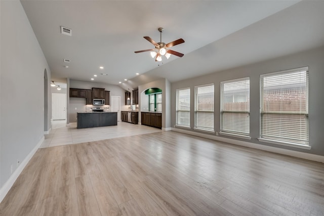 unfurnished living room with ceiling fan, vaulted ceiling, and light hardwood / wood-style flooring