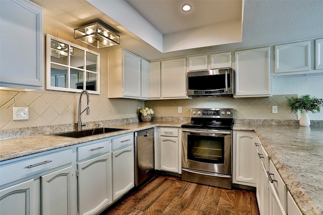 kitchen with stainless steel appliances, sink, and white cabinets