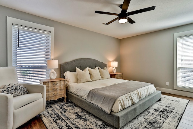 bedroom with ceiling fan, wood-type flooring, and a textured ceiling