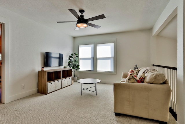 carpeted living room featuring ceiling fan, a textured ceiling, and vaulted ceiling with beams