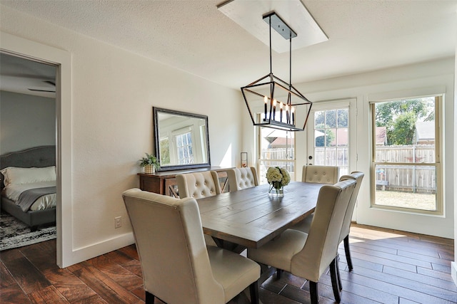 dining room with an inviting chandelier, dark hardwood / wood-style floors, and a textured ceiling