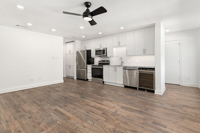 kitchen featuring sink, dark wood-type flooring, white cabinetry, stainless steel appliances, and wine cooler