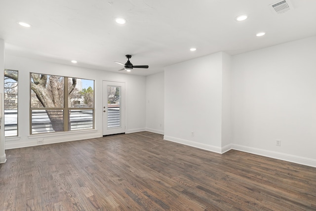 empty room with ceiling fan and dark hardwood / wood-style flooring