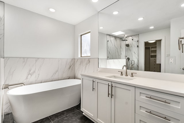 bathroom with vanity, plus walk in shower, tile patterned flooring, and tile walls