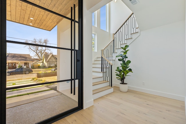 foyer entrance featuring a high ceiling, hardwood / wood-style floors, and wood ceiling