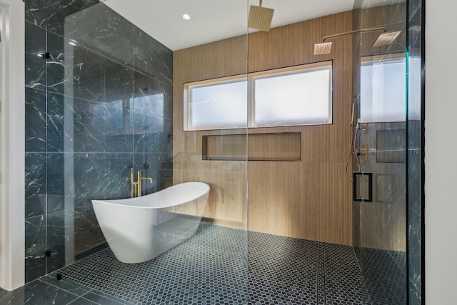 bathroom with tile patterned flooring, shower with separate bathtub, and tile walls