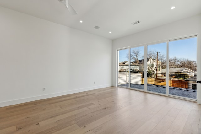 spare room with ceiling fan and light wood-type flooring