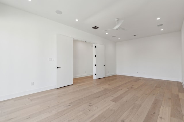 spare room with ceiling fan and light wood-type flooring