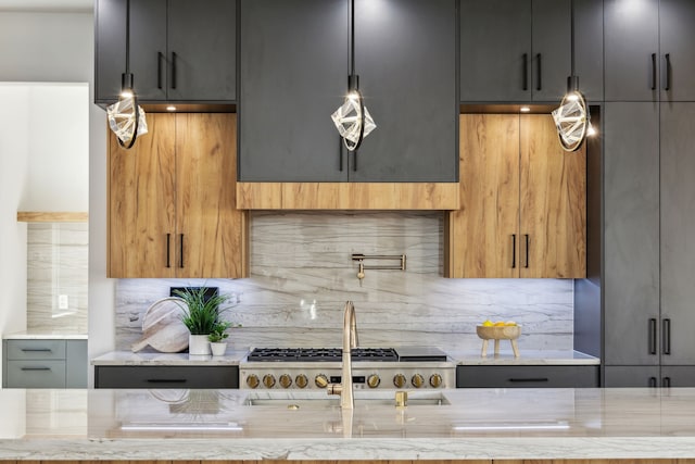 kitchen with light stone counters, decorative light fixtures, tasteful backsplash, and gray cabinets