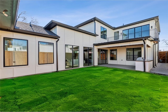 back of property featuring a patio area and a lawn