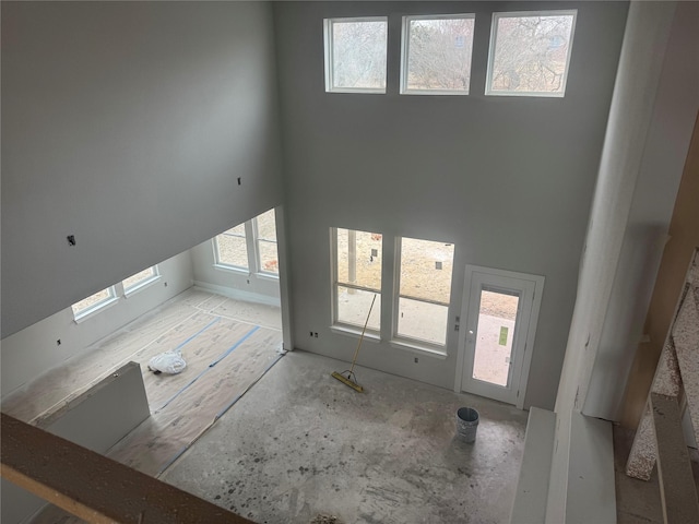 unfurnished living room with a towering ceiling