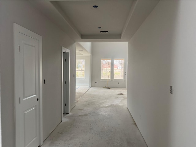 hall featuring a tray ceiling