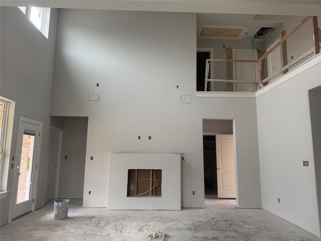 unfurnished living room with a towering ceiling