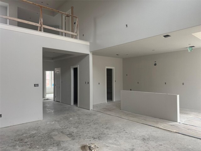 unfurnished living room with a towering ceiling