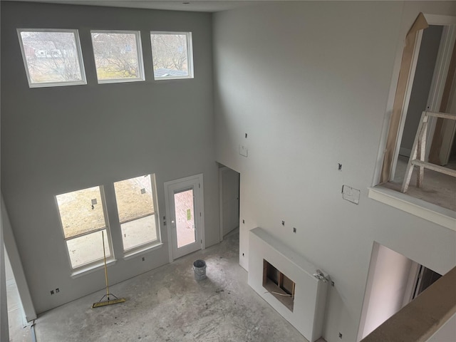 unfurnished living room featuring a high ceiling