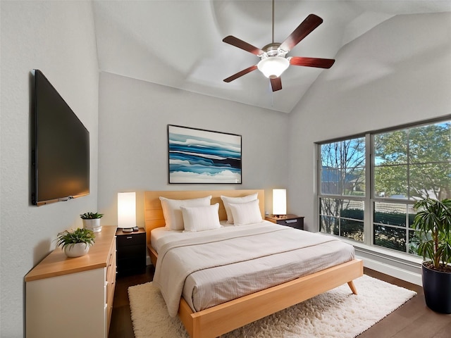 bedroom featuring dark hardwood / wood-style flooring, vaulted ceiling, and ceiling fan