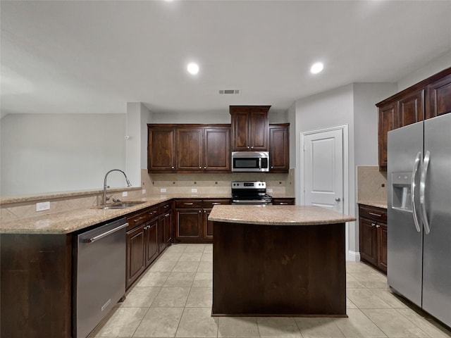 kitchen with dark brown cabinetry, sink, tasteful backsplash, and appliances with stainless steel finishes