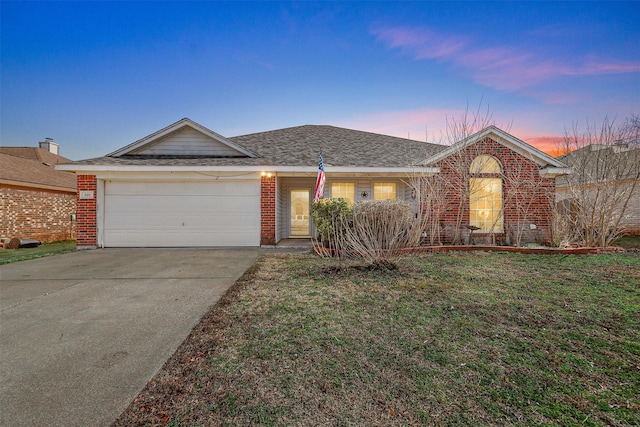 ranch-style home featuring a garage and a yard