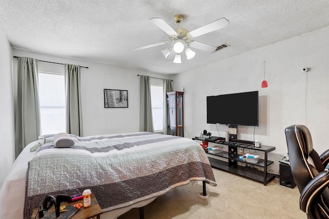 bedroom with ceiling fan and a textured ceiling