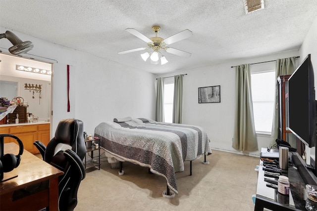 bedroom with multiple windows, a textured ceiling, and ceiling fan