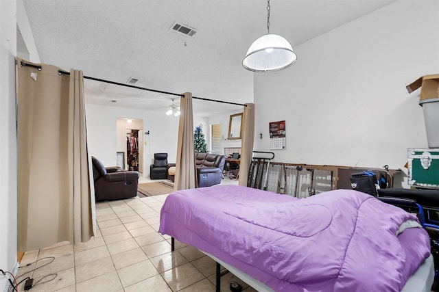 bedroom with light tile patterned flooring, a fireplace, and a textured ceiling