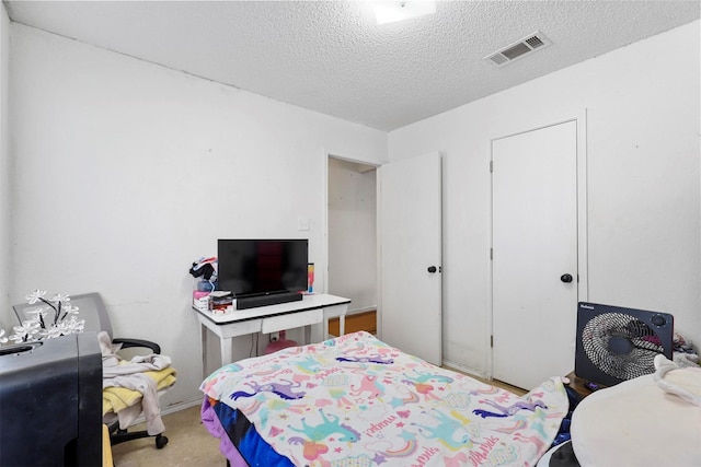 carpeted bedroom featuring a textured ceiling