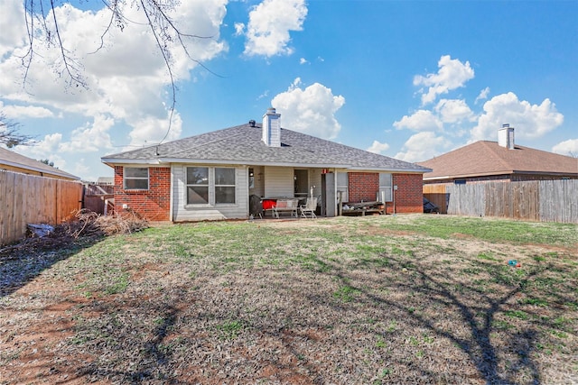 back of property with a yard and a patio area