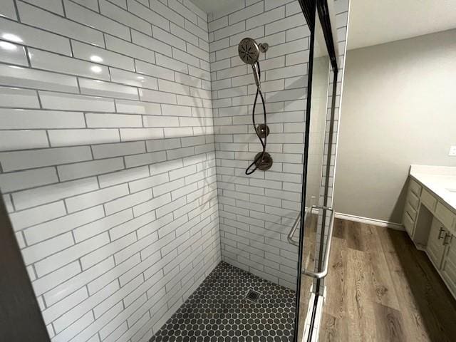 bathroom with a shower with door, vanity, and hardwood / wood-style floors