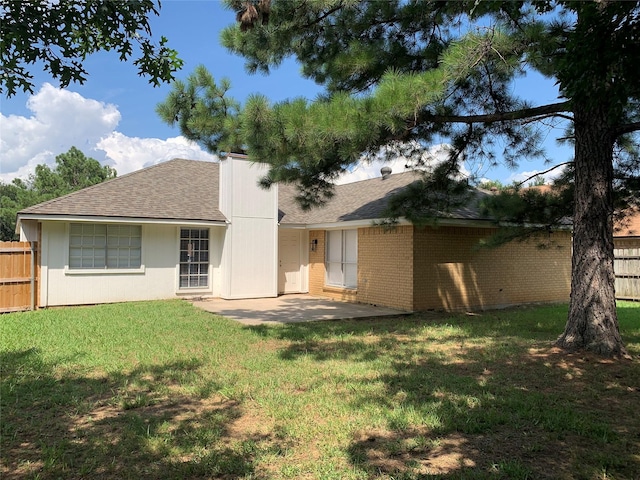 back of house featuring a patio and a lawn