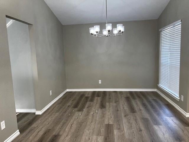 unfurnished dining area with dark hardwood / wood-style floors and a chandelier