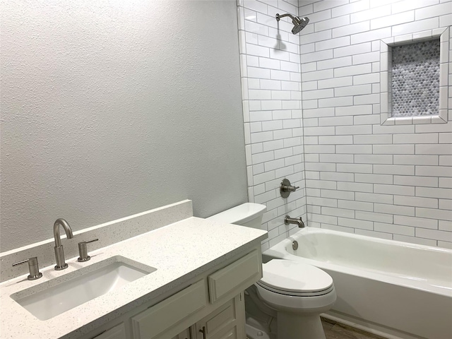 full bathroom with vanity, tiled shower / bath, and toilet