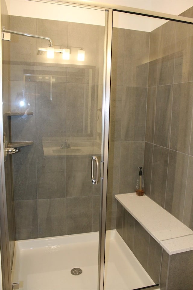 bathroom with a shower with door