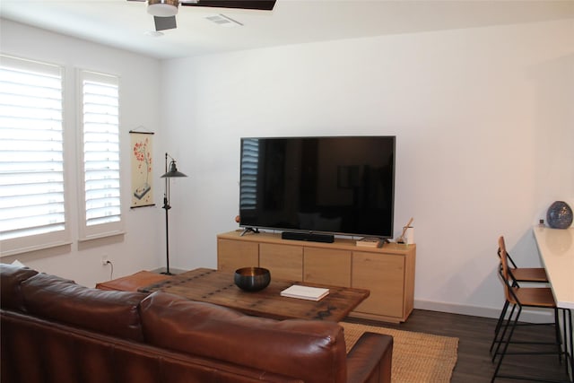 living room featuring dark wood-type flooring and ceiling fan